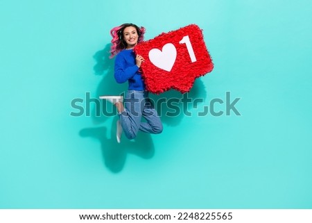 Full body size photo of jumping have fun crazy girl curly hair hold paper like symbol enjoy her insta blog isolated on aquamarine color background