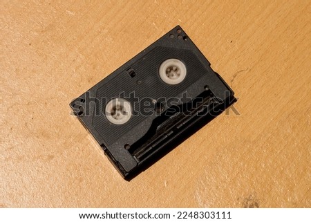 vhs video tape cassette. black classic videography equipment. classic videotape storage tool. brown background