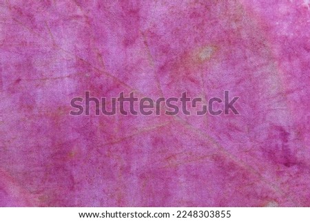 Texture background of natural yellow leaf from eco print process. Colorful Eco-printing on pink fabric background. 