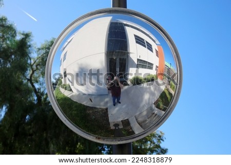 CONVEX MIRROR. Convex mirror to help visibility in traffic. Reflection of a Photographer taking his own photo in a Convex Mirror. Selfie Photo.  