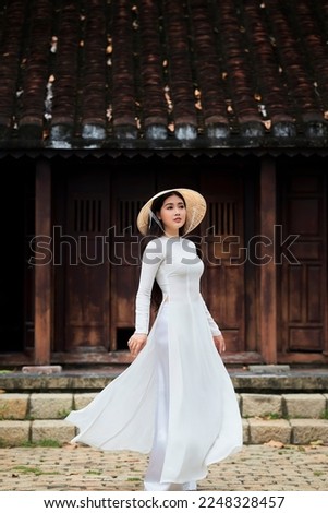 Ho Chi Minh city, Viet Nam: Ao Dai is traditional dress of vietnam, beautiful vietnamese woman in white Ao Dai dress in the park Royalty-Free Stock Photo #2248328457