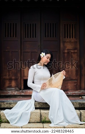 Ho Chi Minh city, Viet Nam: Ao Dai is traditional dress of vietnam, beautiful vietnamese woman in white Ao Dai dress in the park