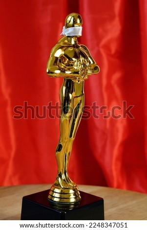 Hollywood Golden Oscar Academy award statue in mask on red background with light rays. Success and victory concept.