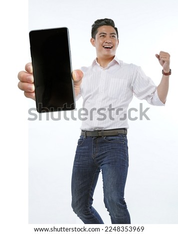 Portrait photo of a young handsome cheerful smile adult man, hold a blank empty giant smart phone, isolated on white background. Concept of promote an app
