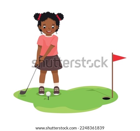 Cute little African girl playing golf ready to hit ball aiming at the hole