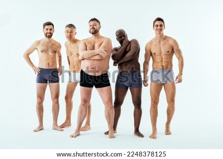 Group of multiethnic men posing for a male edition body positive beauty set. Shirtless guys with different age, and body wearing boxers underwear Royalty-Free Stock Photo #2248378125