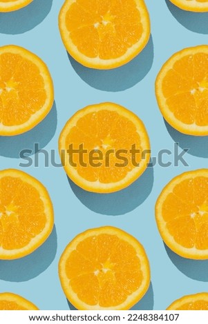 Pattern made of fresh orange halves on blue background. Minimal fruit concept.