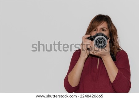 woman with a digital camera about to take a photograph