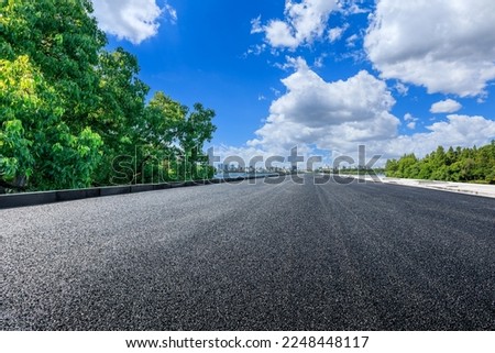 Asphalt road and green tree with city skyline in Hangzhou, China. Royalty-Free Stock Photo #2248448117