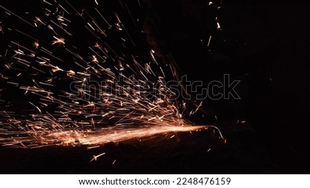 bright sparks from a circular in the dark on a black background close-up. A worker cuts metal with a circular saw close-up. Working with iron.