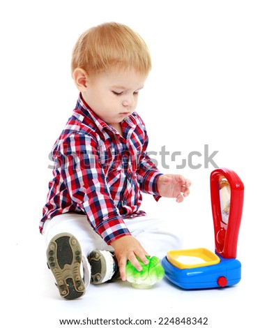 little boy sitting on the floor to be weighed on the scales of toy.Early years learning a happy childhood concept.Isolated on white background.