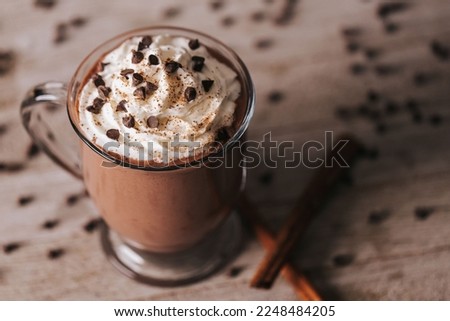 A closeup shot of a cup of hot chocolate on the wooden background