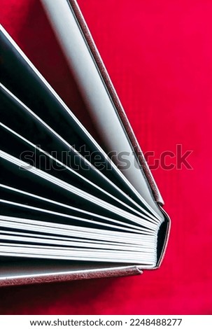 open book in a brown binding on a red background