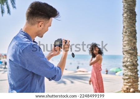 Man and woman couple make photo using camera at seaside