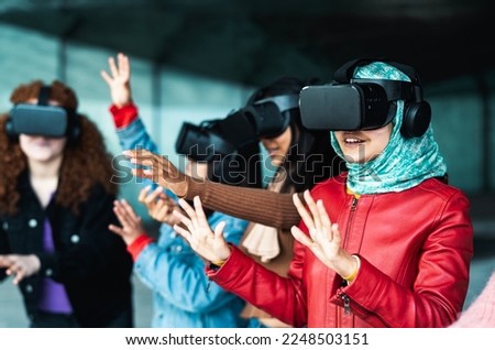 Young multiracial girls using futuristic virtual reality glasses - Technology and metaverse concept Royalty-Free Stock Photo #2248503151