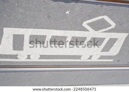 pedestrian crossing with a horizontal road sign drawn on the asphalt: attention tram. Danger symbols on the ground between tram rails for pedestrians at a tram crossing.