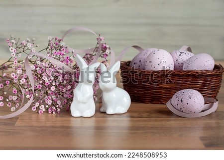 Easter background with colored Easter eggs and blooming flowers. Two Easter Bunnies. Copy space