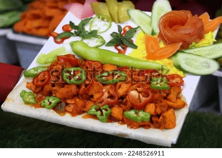 Hand Holding Serving Plate of Mexicano Dish Garnished with Toppings and Dressings  Meat Dishes Stock Photos