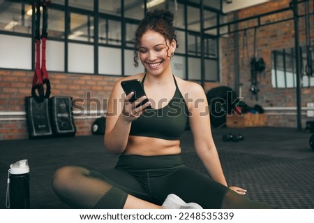 Happy woman, fitness and phone at gym for a workout, training and body wellness with a mobile app. Sports female with smartphone for progress, performance and communication for a healthy lifestyle Royalty-Free Stock Photo #2248535339
