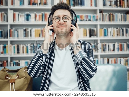Library, student and man with music headphones in university, college or school. Education, learning scholarship and face of young male streaming educational podcast, radio or song, audio or album.