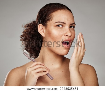 Woman, bad breath and smelling mouth for dental problem, odor and poor oral health in hand. Female with toothbrush for brushing teeth and self care for halitosis, cavity or decay on grey background Royalty-Free Stock Photo #2248535681