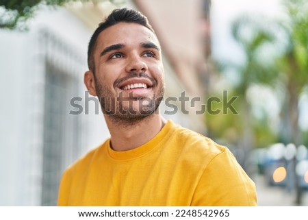 Young hispanic man smiling confident looking to the sky at street Royalty-Free Stock Photo #2248542965