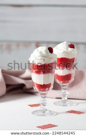 Red velvet cake in glasses with white cream on a white background. A dessert for two lovers for Valentine's Day