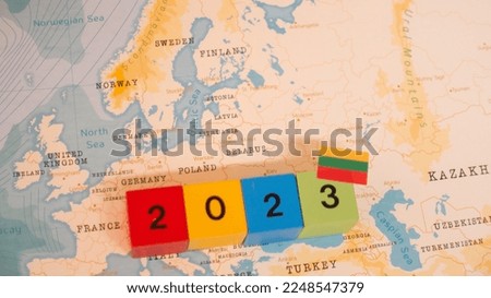 A map and flag of Lithuania with a block with 2023 written on it.