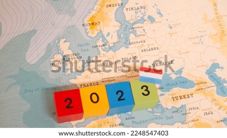 A map and flag of Luxembourg with a block with 2023 written on it.