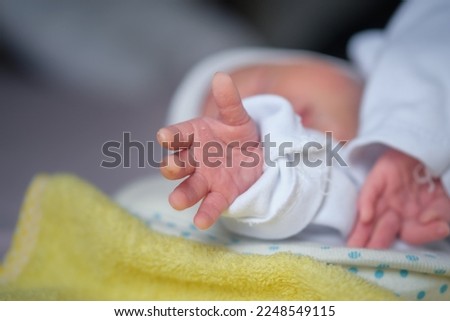 The newborn baby's hand reaches out as if trying to hold something Royalty-Free Stock Photo #2248549115