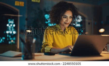 Expressive Multiethnic Middle Eastern Female Working on a Creative Job Position in a Business Agency. Happy Project Manager Browsing Internet, Keeping Important Notes in Notebook. Evening at Work.