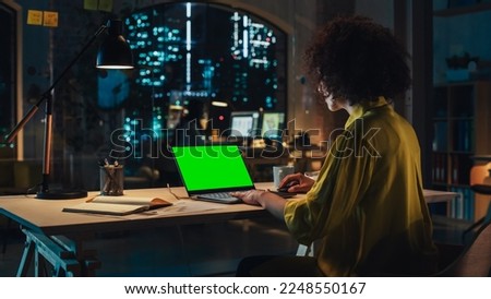 Creative Multiethnic Female Working on Laptop Computer with Green Screen Mock Up Display. Successful Project Manager Browsing Internet, Writing Tasks, Developing a Marketing Strategy for a Partner.