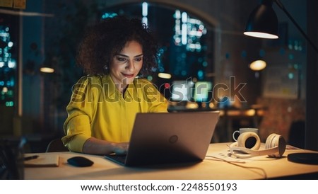 Creative Multiethnic Female Working on Laptop Computer in a Company Office. Happy Project Manager Browsing Internet, Writing Tasks, Developing a Marketing Strategy for Clients.