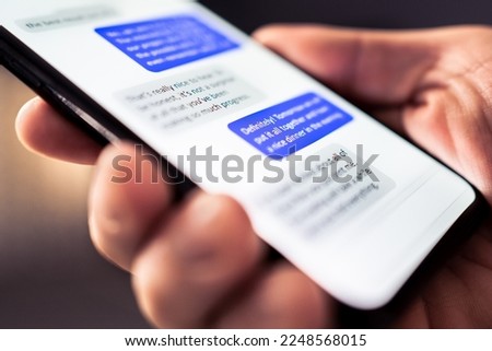 Text message in phone. Send sms with smartphone. Mobile conversation and texting in instant messaging and online chat app in cellphone. Communication in business network. Discussion in dark at night. Royalty-Free Stock Photo #2248568015