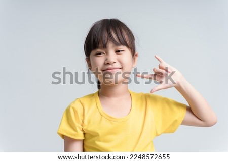 An adorable little asian girl show her hand, the sign hand language "I love you".