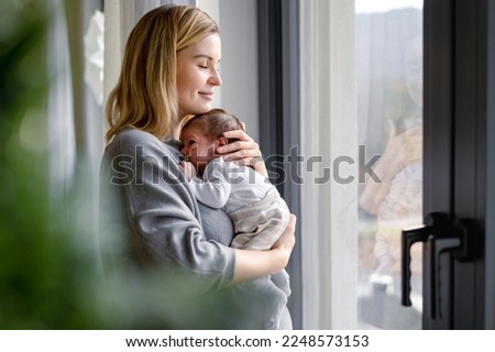 Loving mother hugs her little baby at home Royalty-Free Stock Photo #2248573153