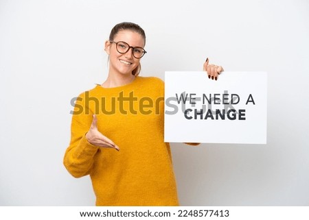 Young caucasian woman isolated on white background holding a placard with text We Need a Change making a deal