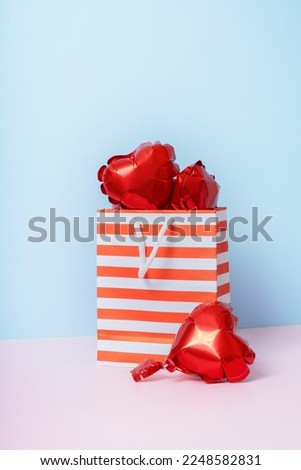 Valentines day sale shopping concept. Red heart shape balloons in shopping bags . High quality photo
