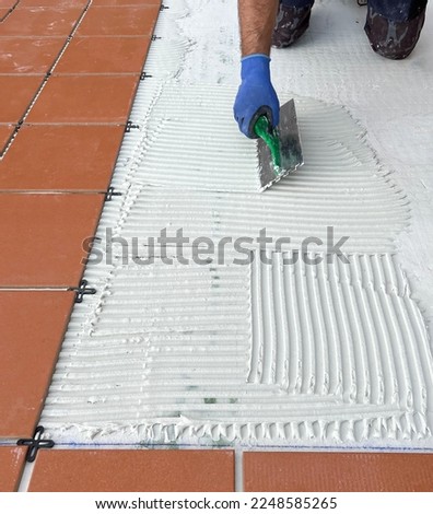 worker spreads the cement glue before applying the ceramic tiles
 Royalty-Free Stock Photo #2248585265
