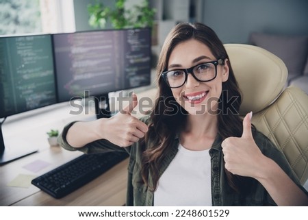 Photo of happy cheerful lady content maker wear glasses smilig showing two thumbs up indoors workstation workshop