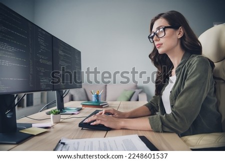 Profile side photo of confident clever lady wear glasses browsing display search bugs mistakes write edits indoor workstation