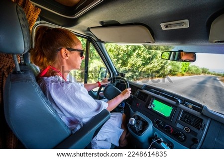 Woman is driving motorhome or campervan on the road outdoors in nature. Motorhome on adventure family trip or journey in nature in Crete, Greece. Exploring on active vacation