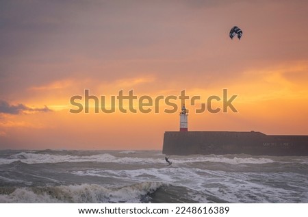 kite surfing on choppy seas during sunset at Newhaven lighthouse and east beach Seaford east Sussex south east England Royalty-Free Stock Photo #2248616389