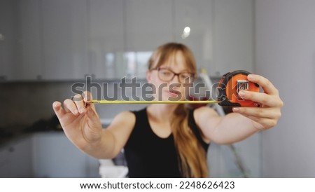 it is time to change something, renovation concept, woman holding a measuring tape at home. High quality photo