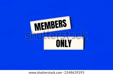 Two wooden blocks with the text MEMBERS ONLY on a blue background. Copy space