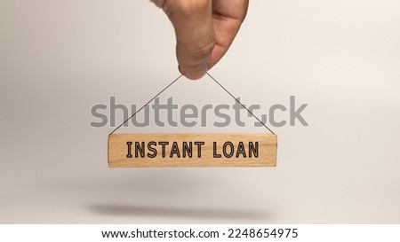 Instant loan text. It is written on a wooden surface. The background is white