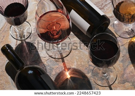Glasses of  rose,white and red wine  with bottles. Wine degustation concept. Selective focus. Royalty-Free Stock Photo #2248657423