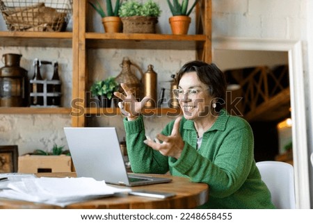 Smiling senior woman filling forms online in home interior. Online working from home. Concept modern technology in stillife.