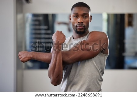 Gym portrait and black man stretching arms for bodybuilder fitness and muscle warm up with focus. Training, wellness and athlete man workout preparation for exercise lifestyle at health club. Royalty-Free Stock Photo #2248658691