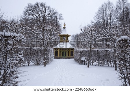 View of Drottningholm Palace gardens in winter. It is the residence of the Swedish royal family and is located near the capital Stockholm, Sweden. The park is covered in snow.